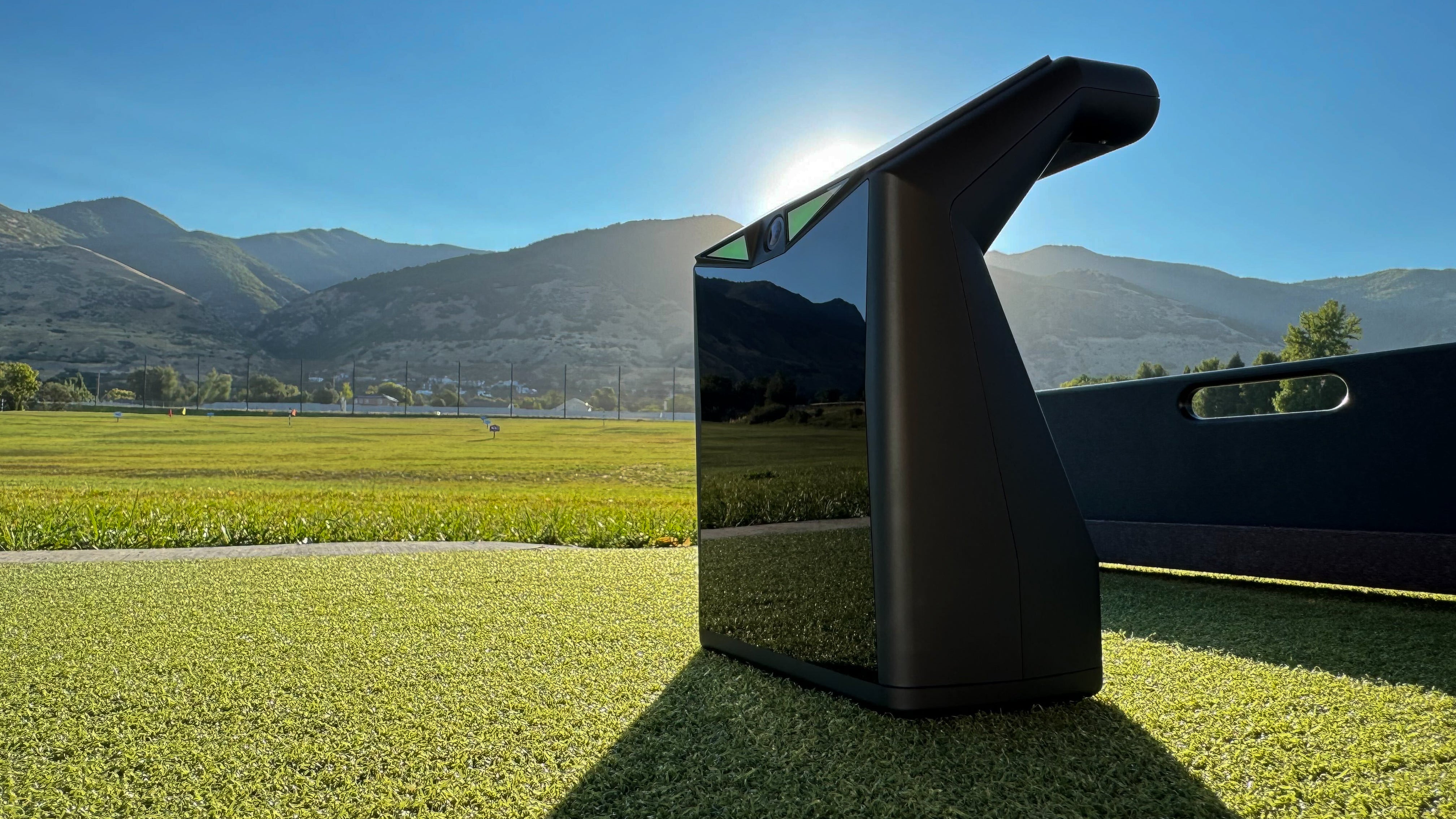 TruGolf LaunchBox portable launch monitor on driving range with mountain backdrop